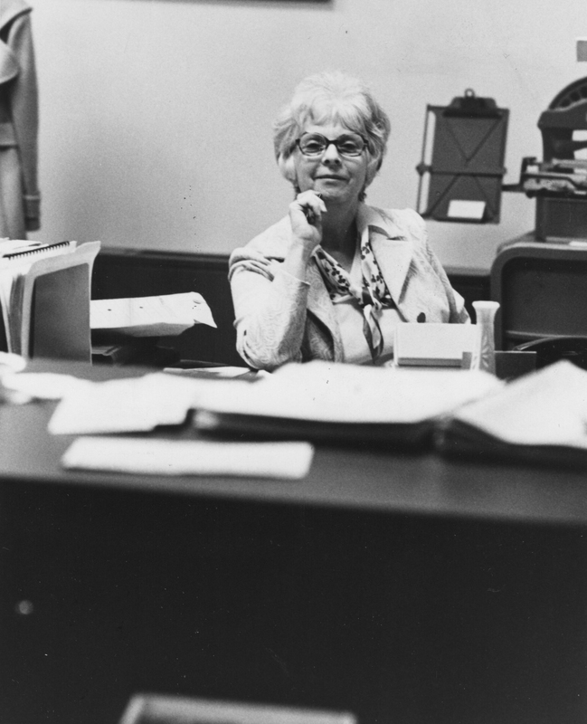 Claire Greene sits at a desk in an office.
