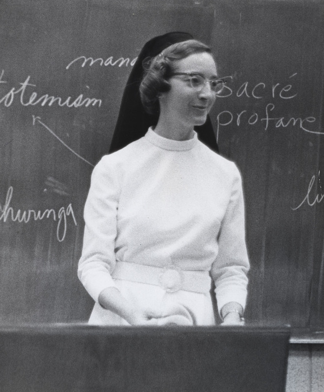 Sister Leslie Straub standing in front of a chalkboard.