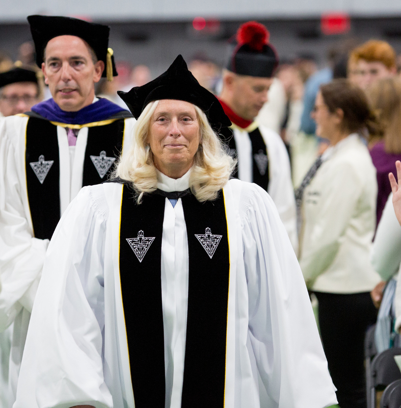 Anne Manchester Molak dressed in academic regalia at a commencement ceremony.