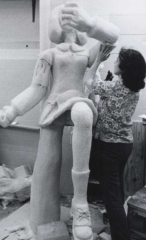 Sister Bernadine M. Egleston working on a large sculpture of a woman.