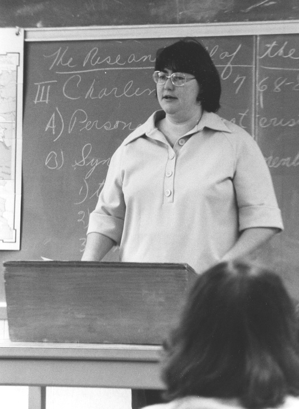 Donna McCaffrey teaching in front of a chalkboard.