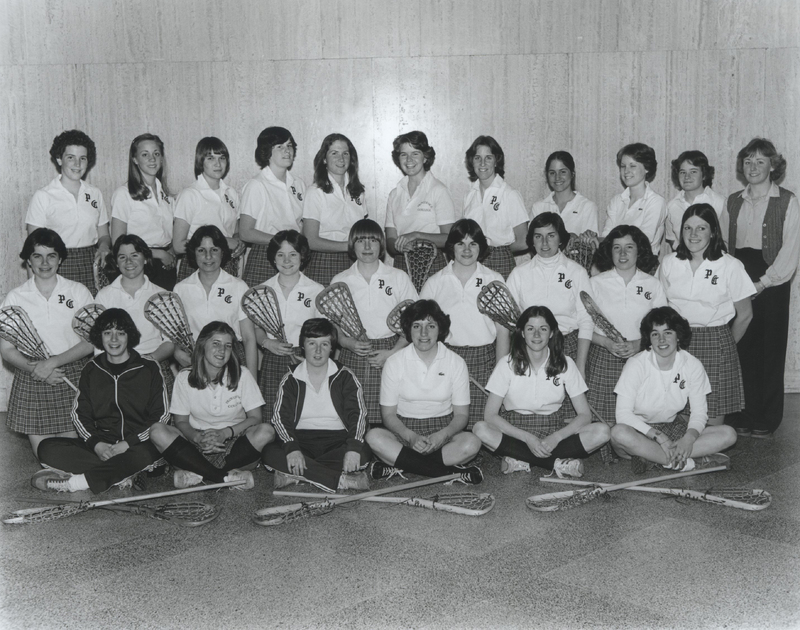 Team photo of the Women's Lacrosse team in Providence College uniforms, some holding hockey sticks.