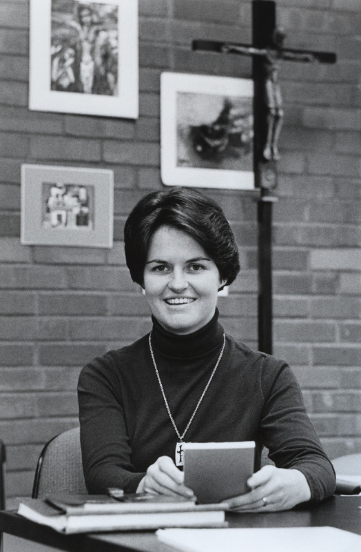 Kathleen O'Connor sitting at a table with a book in her hands.