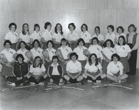 Team photo of the Women's Lacrosse team in Providence College uniforms, some holding hockey sticks.