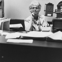 Claire Greene sits at a desk in an office.