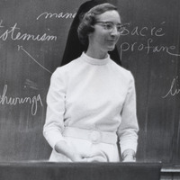 Sister Leslie Straub standing in front of a chalkboard.