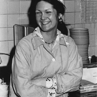 Mary Anne Frieson standing in a kitchen with a dining services uniform on.