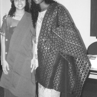 Two students posing for a photograph in a classroom wearing traditional clothing.