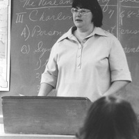 Donna McCaffrey teaching in front of a chalkboard.