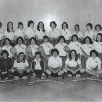 Team photo of the Women's Lacrosse team in Providence College uniforms, some holding hockey sticks.