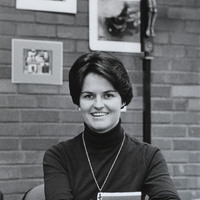 Kathleen O'Connor sitting at a table with a book in her hands.
